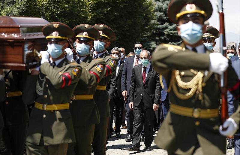 Armenian Prime Minister Nikol Pashinyan (center) attends the funeral Thursday in Yerevan for Maj. Garush Hambardzumyan, who was killed during fighting against Azerbaijani forces on the South Caucasus nations’ shared border. The sides blame each other for continuing attacks in the worst outbreak of hostilities in years. More photos at arkansasonline.com/717conflict/.
(AP/PAN/Government Press Office/Tigran Mehrabyan)