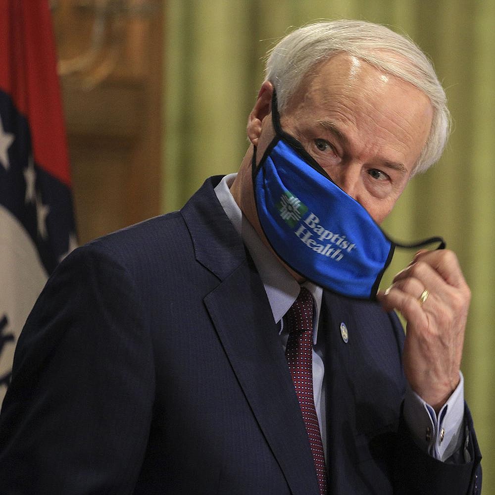 Gov. Asa Hutchinson removes his mask before Thursday’s briefing. “This is not about arresting anyone,” Hutchinson said of the mask mandate. “It’s about education, but it’s also about a penalty, and it’s a consequence, and so they can be issued a citation.” More photos at arkansasonline.com/717governor/.
(Arkansas Democrat-Gazette/Staton Breidenthal)