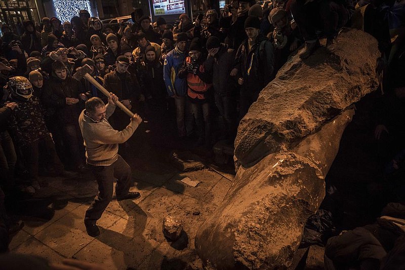 Protesters smash a statue of Lenin after it was pulled down in Kyiv, Ukraine, in December 2013. (The New York Times/Sergey Ponomarev) 
