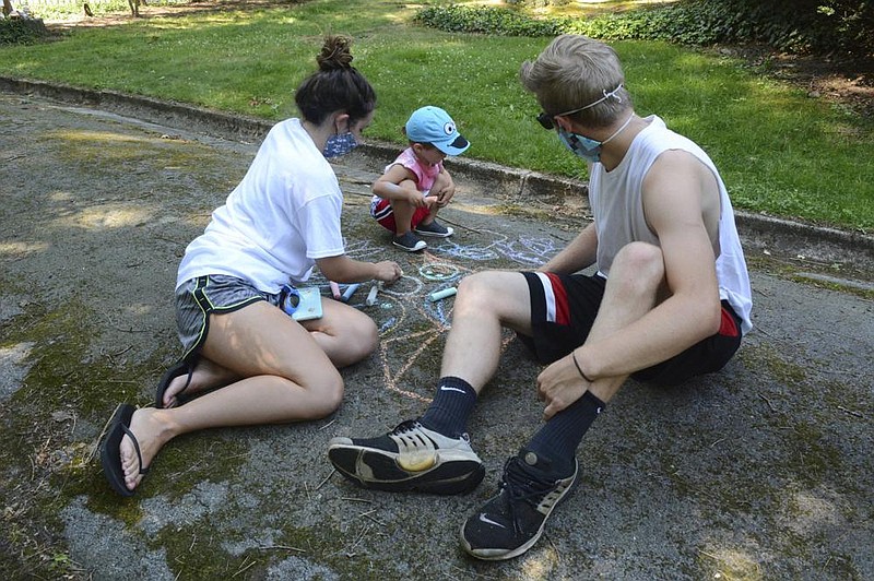Desiree Riegel (from left), Jordan Allan, 2, and Tyler Allan draw Teenage Mutant Ninja Turtles on the driveway of the Schuylkill County Council for the Arts in Pottsville, Pa., during the Messy Art Jamboree on Saturday. 
(AP/Republican-Herald/Lindsey Shuey) 
