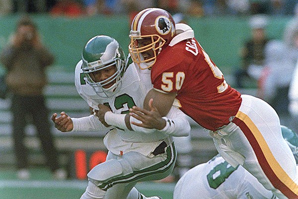 Philadelphia Eagles quarterback Randal Cunningham, left, fumbles the ball as he gets tackled by Washington Redskins linebacker Ravin Caldwell during the first quarter of NFL action from Veterans Stadium in Philadelphia, Dec. 4, 1988. (AP Photo/Rusty Kennedy)

