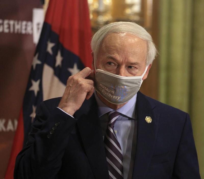 Gov. Asa Hutchinson removes his mask Tuesday, July 16 at the state Capitol in Little Rock before his daily COVID-19 briefing. (Arkansas Democrat-Gazette/Staton Breidenthal)