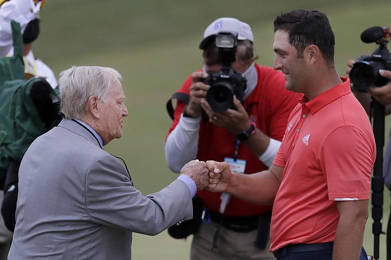 Jon Rahm (right) is congratulated by tournament host Jack Nicklaus on Sunday after winning the Memorial at Muir eld Village in Dublin, Ohio. (AP/Darron Cummings) 
