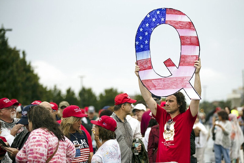 David Reinert holds a Q sign as he waits with others to enter a campaign rally featuring President Donald Trump in Wilkes-Barre, Pa., in this Aug. 2, 2018, file photo. The "Q" refers to QAnon, the idea that a high-ranking government official known only as "Q" has been revealing a plot to stop Trump from saving Americans from a "deep state" filled with child-abusing, devil-worshiping Democrats and bureaucrats.