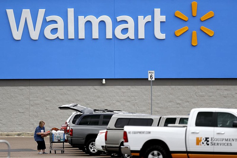 A woman loads groceries into her vehicle at a Walmart store in Pearl, Miss. Walmart announced that its stores will be closed Thanksgiving Day.  (AP file photo)