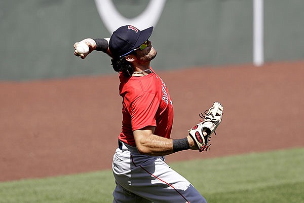 Boston Red Sox left fielder Andrew Benintendi throws to first base during baseball practice at Fenway Park, Thursday, July 16, 2020, in Boston. (AP Photo/Steven Senne)