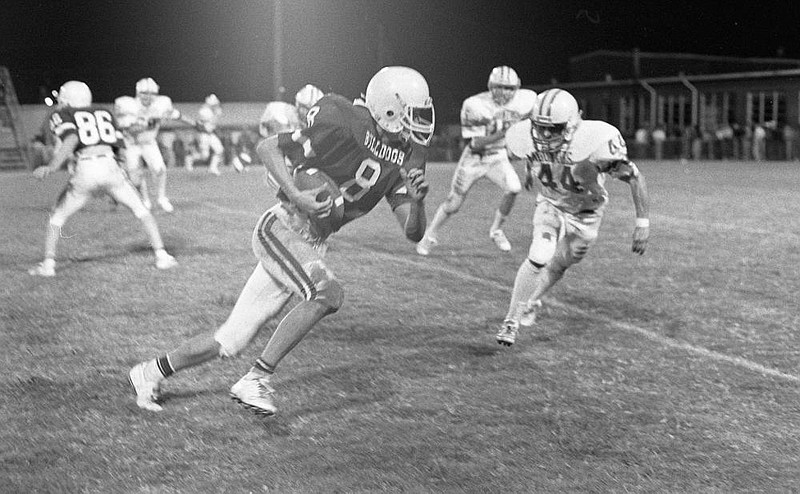 Chris Smith (8) finds running room against Rogers in a 1987 game in Springdale. Smith was a standout for the Red'Dogs and helped lead the University of Central Arkansas to the 1991 NAIA national championship. 

File photo Shiloh Museum from the Springdale Morning News collection