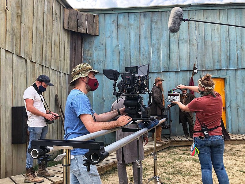 Crew members set up during the filming of “Ghosts of the Ozarks,” which is one of the few movies that’s being produced during the covid-19 pandemic. The movie is currently being shot in Trumann and other locations around the state. Producer and cast member David Arquette can be seen just to the right of the slateboard. 