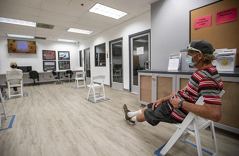 Gregory Newland, a former electrician who lives in a tent on the street, watches a movie in an air-conditioned cooling center at Martha’s Village & Kitchen in Indio, Calif., after walking several miles to get to there.
(Los Angeles Times/Allen J. Schaben)