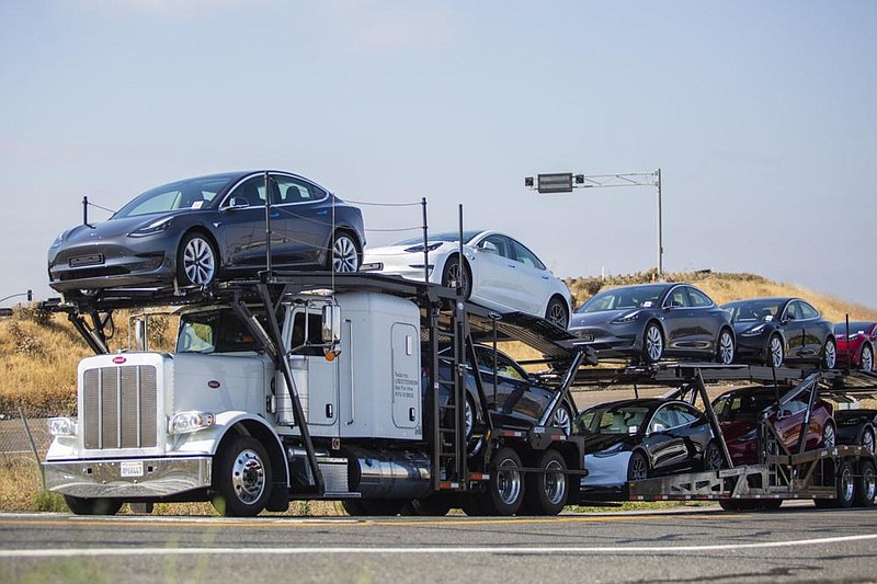 An auto transport trailer carries Tesla Inc. electric vehicles outside the company’s factory in Fremont, Calif., last week. (Bloomberg/Nina Riggio) 