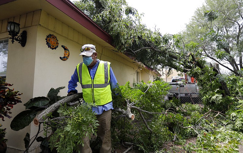 Juan Martinez helps clear debris left by Hurricane Hanna, Monday, July 27, 2020, in Weslaco,Texas. The area was flooded by Hurricane Hanna as it passed through the area dropping heavy rains which caused flooding. (AP Photo/Eric Gay)

