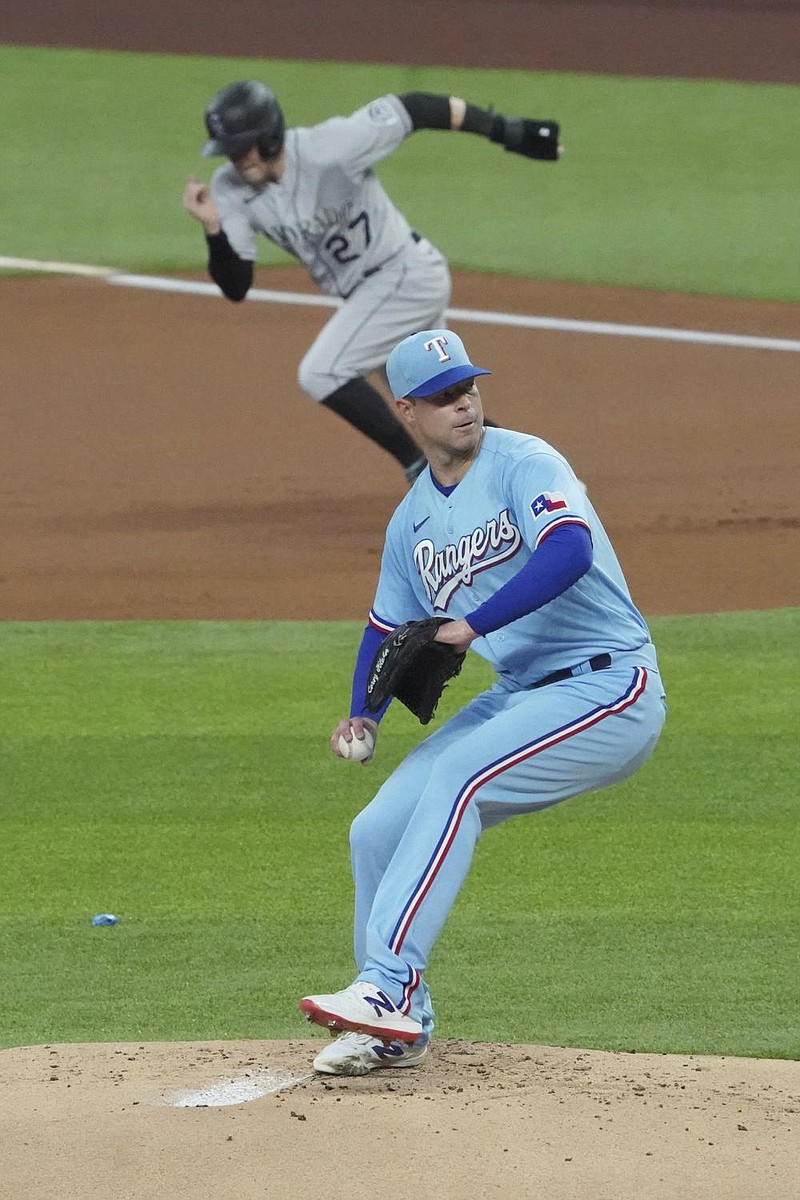 Two-time Cy Young Award winner Corey Kluber pitches in his debut for the Texas Rangers as Trevor Story of the Colorado Rockies breaks from first Sunday in Arlington, Texas. Kluber left after the first inning with shoulder tightness, and Story, a Dallas-area native, hit two home runs to help the Rockies win 5-2. 
(AP/Louis DeLuca) 
