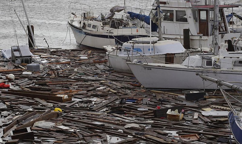 Debris floats around damaged boats in a marina Sunday after Hurricane Hanna hit Corpus Christi, Texas. About 30 boats were lost or damaged in the storm at the marina. More photos at arkansa- sonline.com/727hanna/ (AP/Eric Gay) 