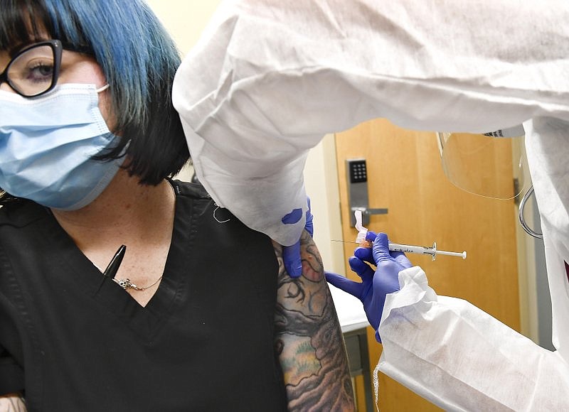 Nurse Kathe Olmstead, right, gives volunteer Melissa Harting, of Harpersville, N.Y., an injection as the world’s biggest study of a possible COVID-19 vaccine, developed by the National Institutes of Health and Moderna Inc., got underway Monday, July 27, 2020, in Binghamton, N.Y. story.lead_photo.caption