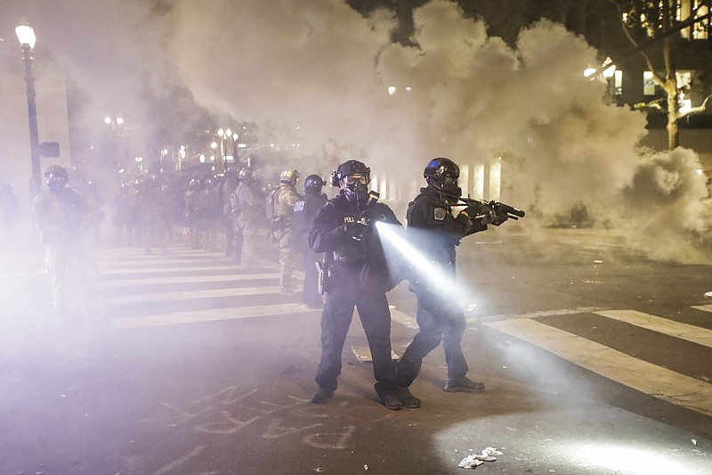Federal officers deploy tear gas and crowd control munitions at demonstrators during a Black Lives Matter protest at the Mark O. Hatfield United States Courthouse Tuesday, July 28, 2020, in Portland, Ore. (AP Photo/Marcio Jose Sanchez)