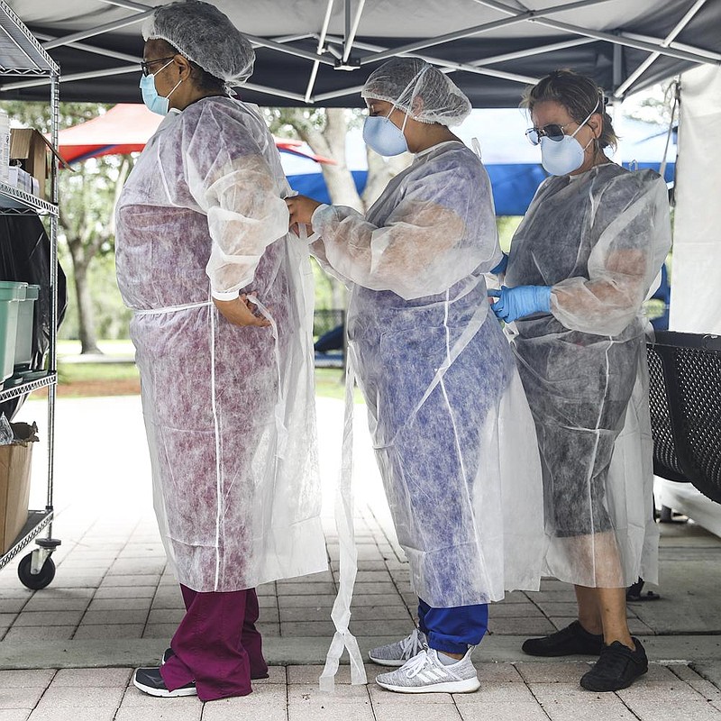 Health care workers get ready for their shift Tuesday at a coronavirus testing site in Orlando, Fla. (The New York Times/Eve Edelheit)