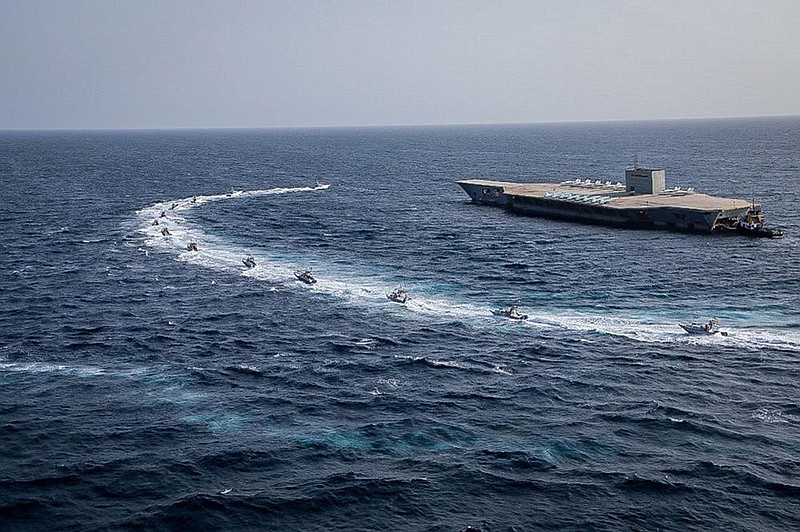 In this photo released Tuesday by Sepahnews, Iranian Revolutionary Guard speed boats circle a replica of an aircraft carrier during a military exercise in the Strait of Hormuz. (AP/Sepahnews) 
