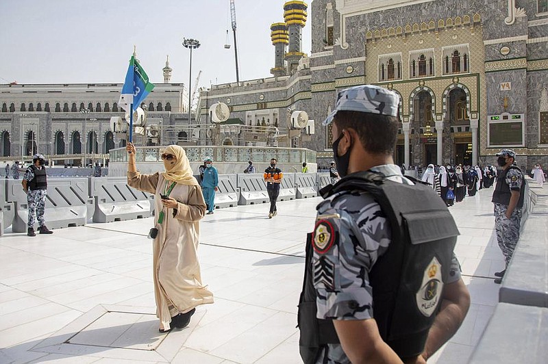 Saudi security forces keep watch Wednesday as pilgrims arrive at the Grand Mosque at Mecca. The pilgrims, who were selected after applying through an online portal, were required to be between ages 20 and 50, with no terminal illnesses and no apparent coronavirus symptoms.
(AP/Saudi Media Ministry)