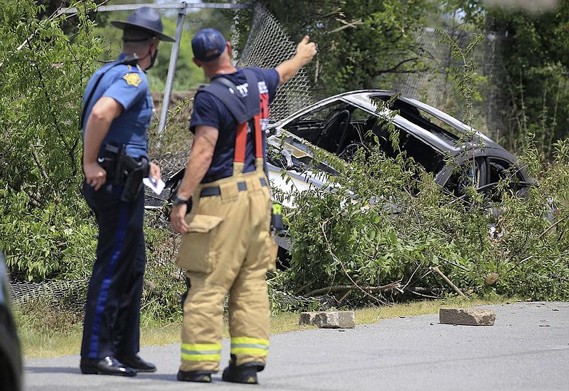 An Arkansas state trooper talks with a Little Rock firefighter Thursday at the scene of a car crash and fire near West Eighth and South Valentine streets in Little Rock.
(Arkansas Democrat-Gazette/Staton Breidenthal) story.lead_photo.caption
