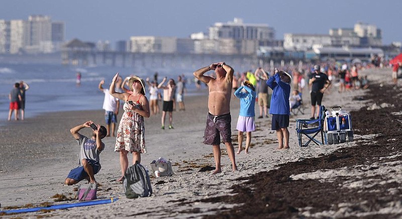 People on the beach Thursday at Cherie Down Park in Cape Canaveral, Fla., watch the launch of the Atlas V rocket as it starts the Mars Perseverance rover on its way to Mars.
(AP/Florida Today/Malcolm Denemark)