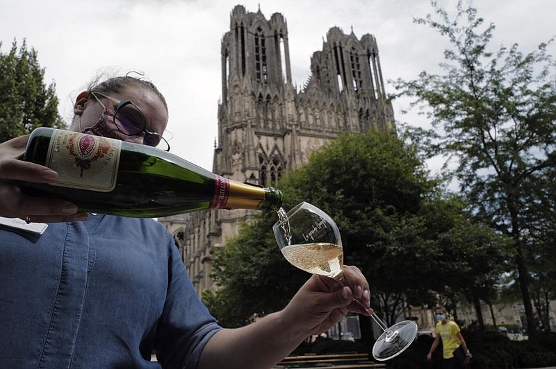 A waitress serves Champagne earlier this week at La Grande Georgette restaurant in Reims in France’s Champagne region. Sales of the beverage have fizzled as celebrations have been muted by the pandemic.
(AP/Francois Mori)