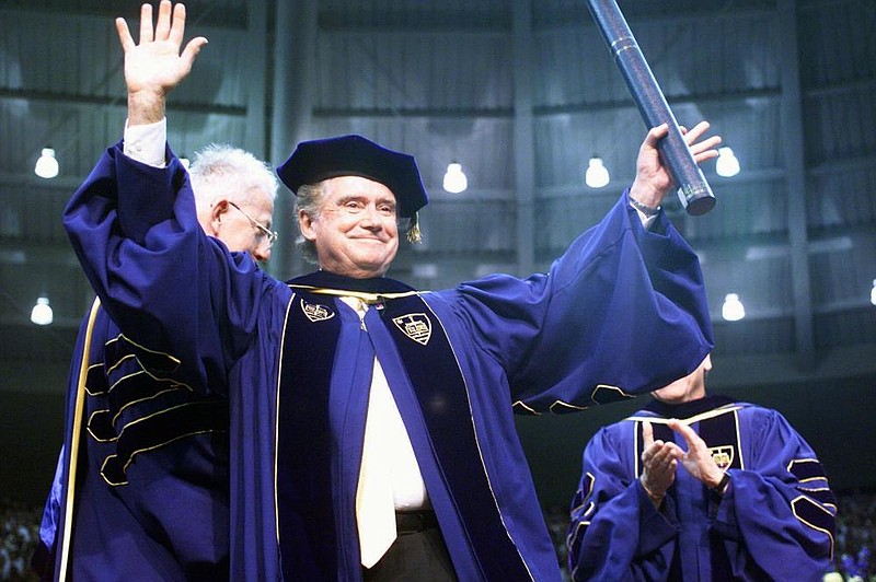 In this May 16, 1999, file photo, Regis Philbin, a Notre Dame graduate, waves to the crowd after receiving an honorary degree during Notre Dame's 154th commencement exercises in South Bend, Ind. Philbin, who died last week at 88, has been buried at the university's Cedar Grove Cemetery, following a private funeral service Wednesday, July 29, 2020. (AP Photo/Joe Raymond)