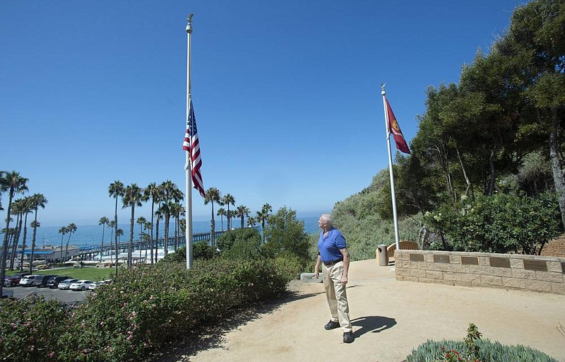 Former San Clemente Mayor Wayne Eggleston lowered the U.S. flag Friday at Park Semper Fi in San Clemente, Calif., after Thursday’s fatal military accident.
(AP/The Orange County Register/Paul Bersebach)
