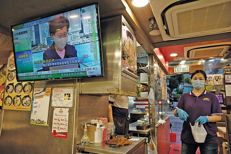 A TV screen at a Hong Kong restaurant shows the city’s chief executive, Carrie Lam, announcing on Friday the postponement of legislative elections.
(AP/Vincent Yu)