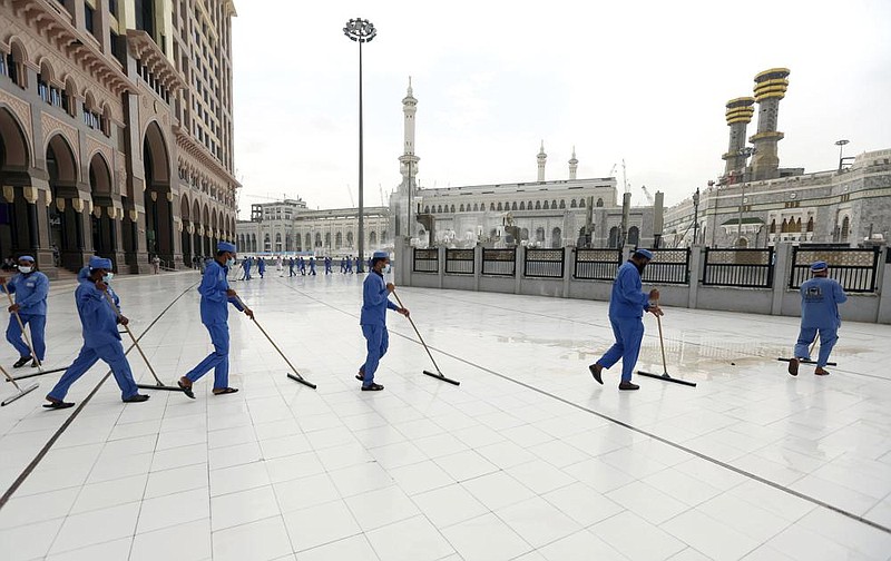 Workers in Mecca, Saudi Arabia, disinfect the ground outside the Grand Mosque on Monday, over fears of the new coronavirus. Between 1,000 and 10,000 people will make the pilgrimage, one of the five pillars of Islam, down from the around 2.5 million pilgrims who came to the holy site last year.
(AP)