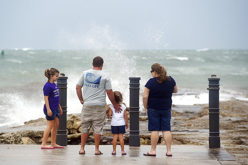 Elizabeth Whittemore (from left), along with her father James, sister Jordan and mother Susan, stand at the end of the South Jetty in Fort Pierce on Sunday, Aug. 2, 2020, watch the waves crash over the rocks brought by the high winds of Tropical Storm Isaias churning off the coast.