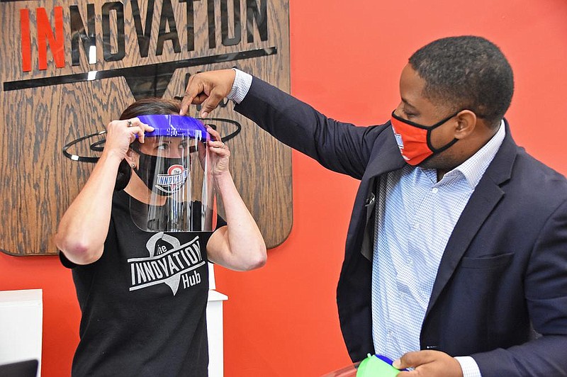 Errin Stanger (left), deputy director, and Chris Jones, executive director and lead maker, talk Friday about the 3D printing options for personal protective equipment being made at the Arkansas Inno- vation Hub in Little Rock. (Arkansas Democrat-Gazette/Staci Vandagriff) 
