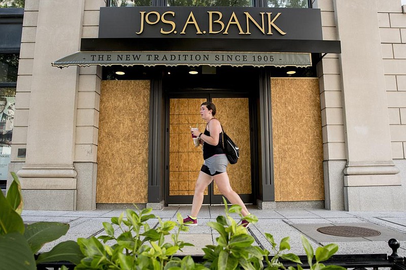 A woman passes a JoS. A. Bank clothing store on Monday in Washington. Tailored Brands, the parent company of JoS. A. Bank and Men’s Wearhouse, has filed for bankruptcy. (AP/Andrew Harnik) 
