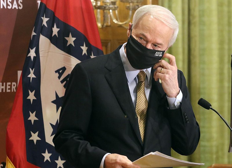 Gov. Asa Hutchinson takes off his mask before the daily covid-19 press briefing on Wednesday, Aug. 5, 2020, at the state Capitol in Little Rock. (Arkansas Democrat-Gazette/Thomas Metthe)