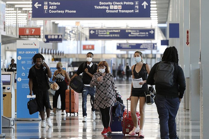 Travelers navigate O’Hare International Airport in Chicago in this June photo. Airline officials are meeting with congressional and White House leaders to extend stimulus funds to help the pandemic- crushed industry. (AP) 
