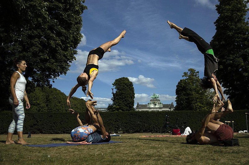 Acrobats perform gymnastic stunts Tuesday as they work out at the Cinquantenaire park in Brussels. (AP/Francisco Seco) 