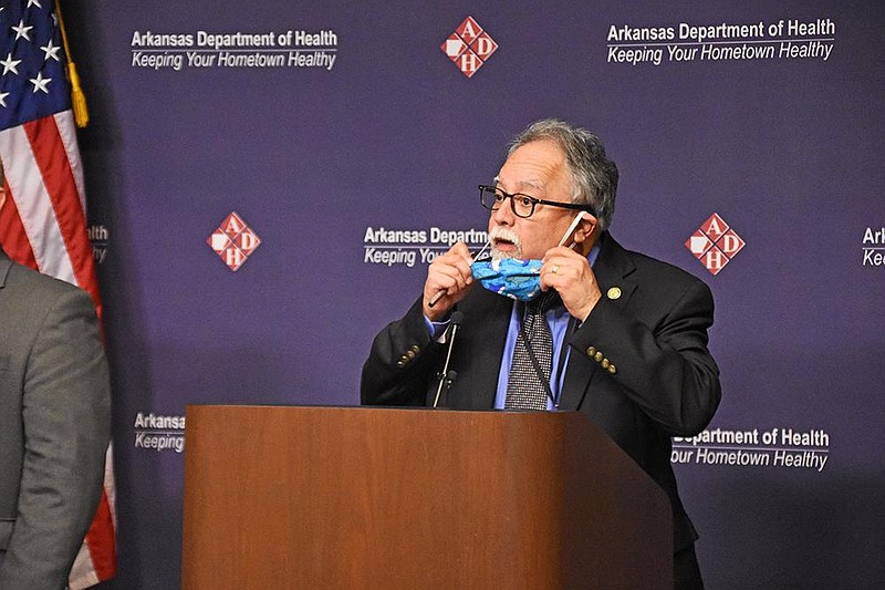 Dr. Jose Romero, Secretary of the Arkansas Department of Health, removes his mask before answering questions from the media during a COVID-19 press briefing Thursday, Aug. 6, at the Arkansas Department of Health in Little Rock. (Arkansas Democrat-Gazette/Staci Vandagriff)