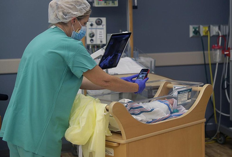 Nurse Amanda Vaughan takes photos in the maternity ward at the DHR Health hospital in McAllen, Texas, and helps new mother Clarissa Munoz, who is infected with covid-19, see her baby on an iPad. Munoz was separated from her child after giving birth.
(AP/Eric Gay)