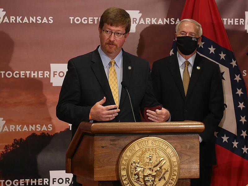 Arkansas Secretary of Education Johnny Key (left) answers a question while Gov. Asa Hutchinson listens during the daily covid-19 press briefing on Wednesday, Aug. 5, 2020, at the state Capitol in Little Rock. Key said Wednesday that because of the Arkansas Constitution's requirement for the state to offer students an adequate education, all districts must offer in-person classes, five days a week, in the fall of 2020.