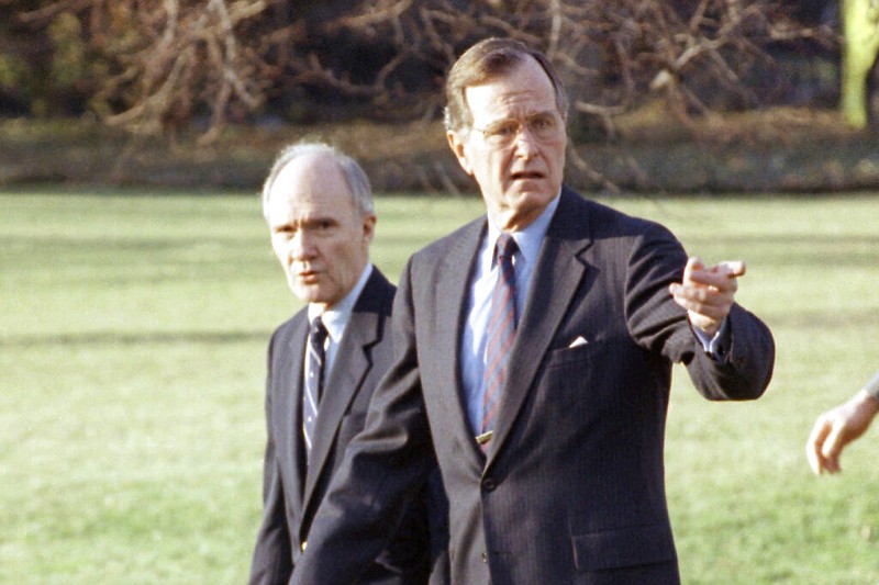 President George H.W. Bush gestures as he and National Security Adviser Brent Scowcroft walk to the presidential helicopter on the South Lawn of the White House in Washington in this Feb. 6, 1990, file photo.