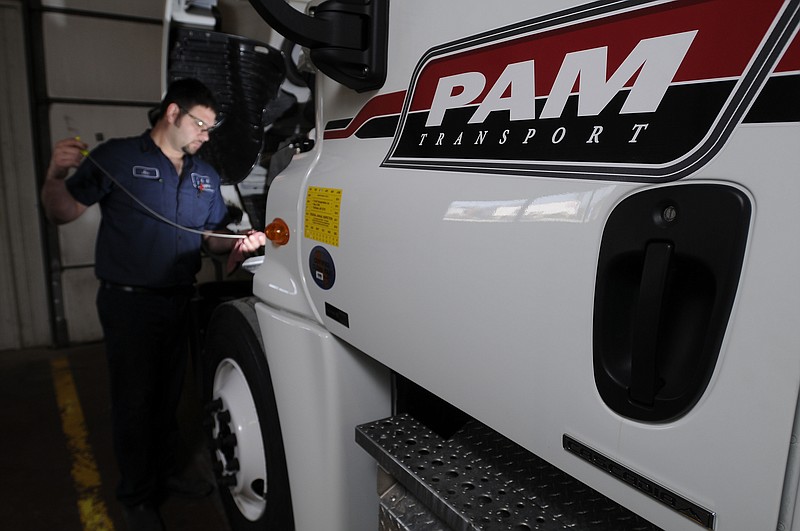 Joe Embry, a diesel technician with PAM Transport, checks the oil on a truck Wednesday, March 23, 2011, at the truck garage in Tontitown during a preventative maintenance inspection. (NWA Democrat-Gazette/FILE PHOTO)
