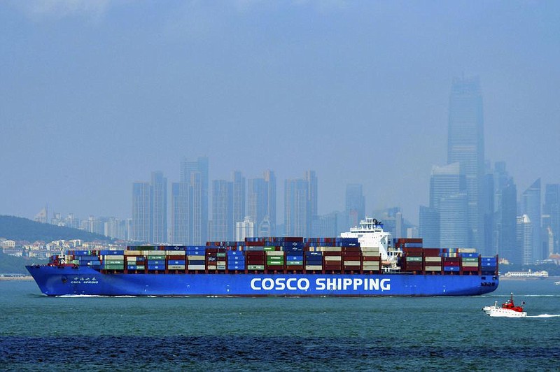 A Chinese container ship sails past the skyline of Qingdao in eastern China. Chinese exports have benefited from a surge in demand for Chinese-made surgical gloves, masks and other medical supplies.
(AP)
