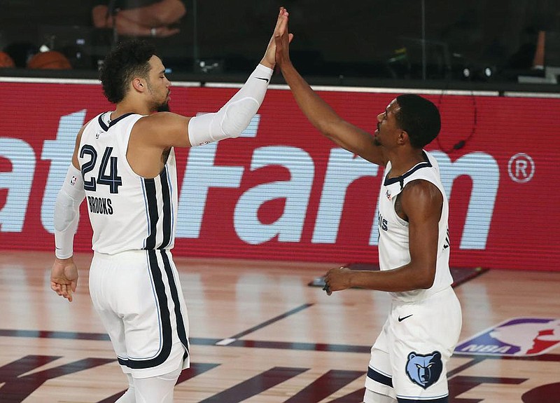 Memphis guard Dillon Brooks (24) celebrates with teammate De’Anthony Melton after making a play during Friday’s 121-92 victory over the Oklahoma City Thunder in Lake Buena Vista, Fla. Brooks scored 22 points as the Grizzlies won for the first time since the NBA’s restart.
(AP/Kim Klement)