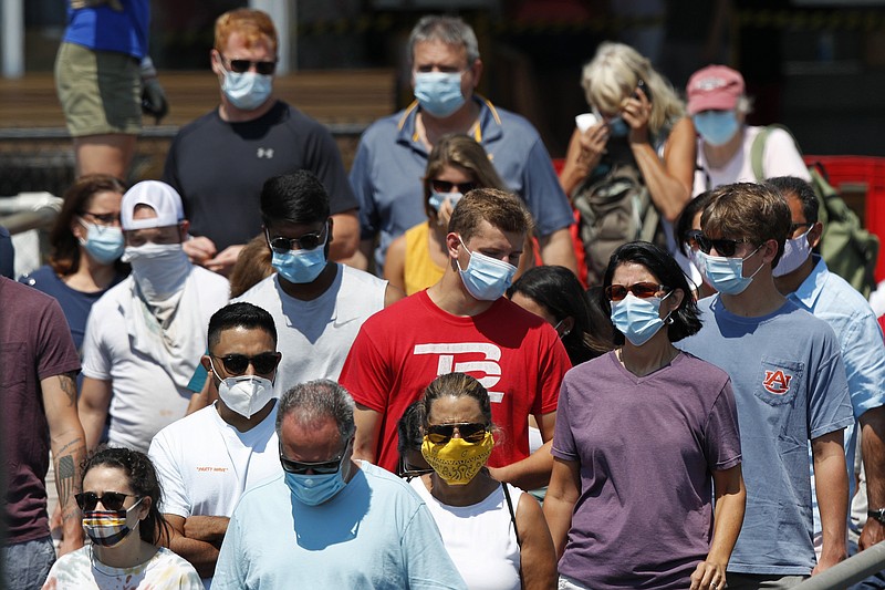 FILE - In this July 30, 2020, file photo, passengers board a Casco Bay Lines ferry bound for Peaks Island in Portland, Maine. America's failure so far to contain the spread of the coronavirus as it moves across the country has been met with astonishment and alarm on both sides of the Atlantic. 