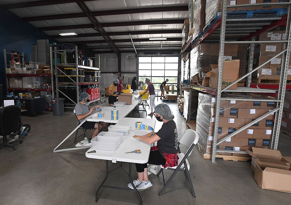 Employees along with some restaurant workers make meal packs July 29 at The Pack Shack in
Cave Springs. Visit nwaonline.com/200809Daily/ for photo galleries.
(NWA Democrat-Gazette/J.T. Wampler)