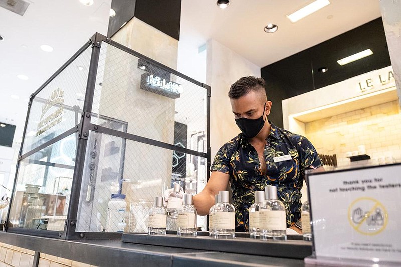 A worker disinfects perfume bottles at Bloomingdale’s agship store in New York. (Bloomberg/Jeenah Moon) 