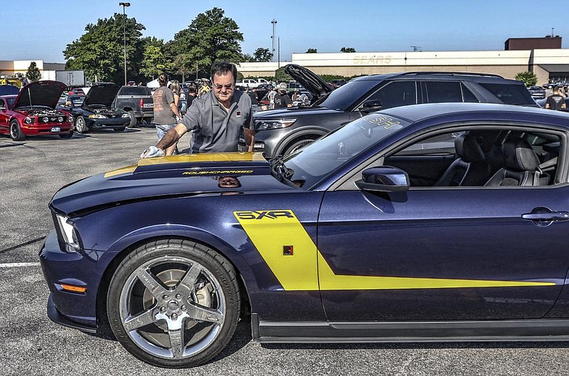 Dale Priddy of Elizabethtown polishes his 2011 Roush 5XR Mus- tang on Saturday while showing the car in the Owensboro Cars and Coffee car show in Owensboro, Ky. (AP/The Messenger-Inquirer/Greg Eans) 