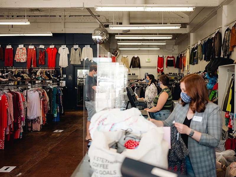 Cashiers and customers are separated by plexiglass at the check out counter at Crossroads Trad- ing, a consignment store with used and new clothing, in Studio City, Calif. Sites like Poshmark and Thredup have thrived during the pandemic, but your neighborhood thrift store is not doing so well. (The New York Times/Rozette Rago) 