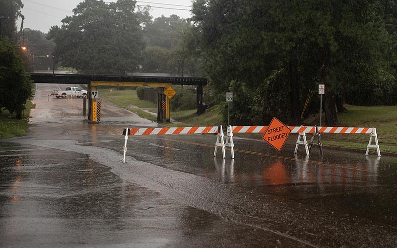 A sign blocks vehicles from traveling under a bridge Wednesday on West 40th Street in Texarkana, Texas. The region saw heavy rain throughout the morning, prompting flash flood warnings.
(Texarkana Gazette/Jason Hopkins)