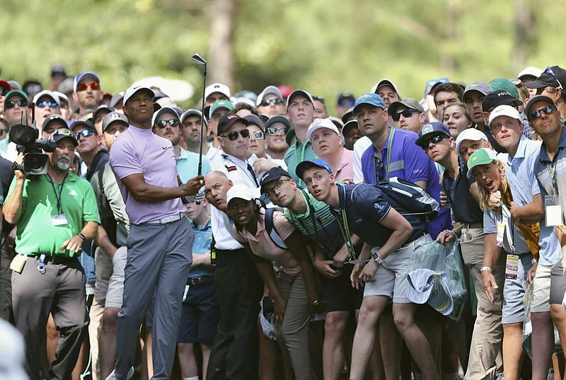 Patrons at Augusta National Golf Club watch a shot by Tiger Woods during the 2019 Masters. The club announced Wednesday that spectators will be not be allowed to this year’s tournament because of the coronavirus pandemic. It has already been moved from April to November due to concerns over the pandemic.
(AP file photo)