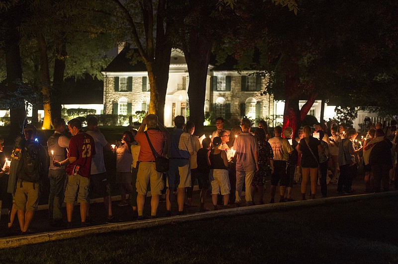 Visitors participate in a candlelight vigil for Elvis Presley at Graceland, Presley's Memphis home, in this Aug. 15, 2017, file photo. Fans from around the world have traditionally gathered at Graceland for a vigil every Aug. 15, the eve of the anniversary of Elvis Presley's death on Aug. 16, 1977.